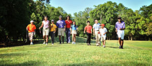 group of diverse golfers walking safely